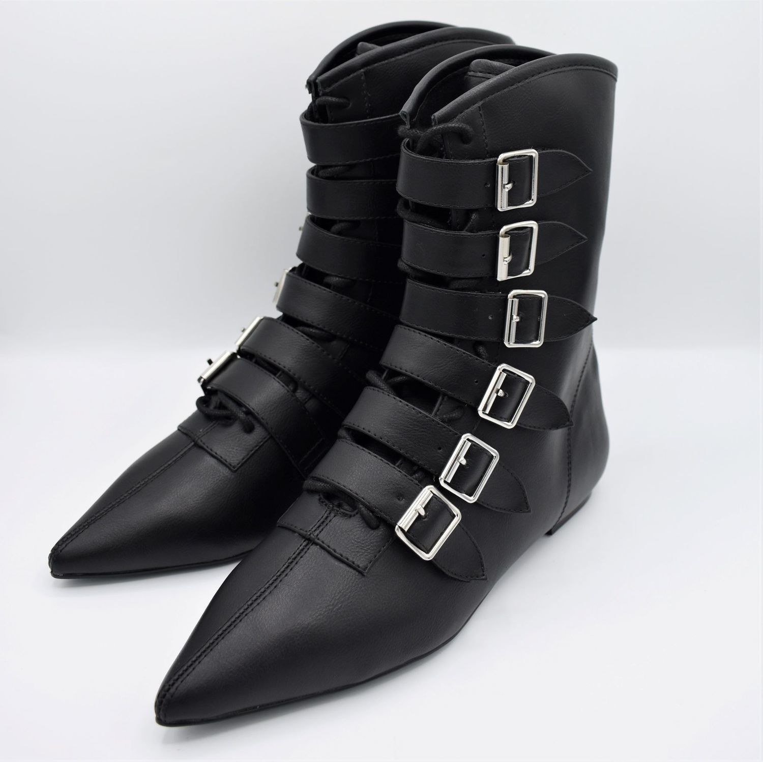 black shoe with a pointy toe and many buckle clasps