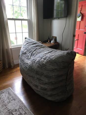 the gray cushion on its side and it takes up a large portion of a room