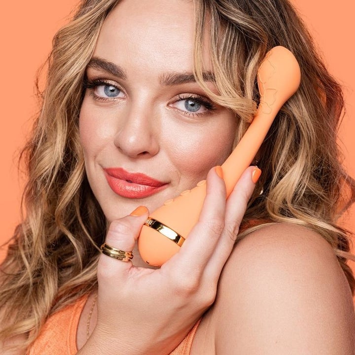 Model smiling with vibrator