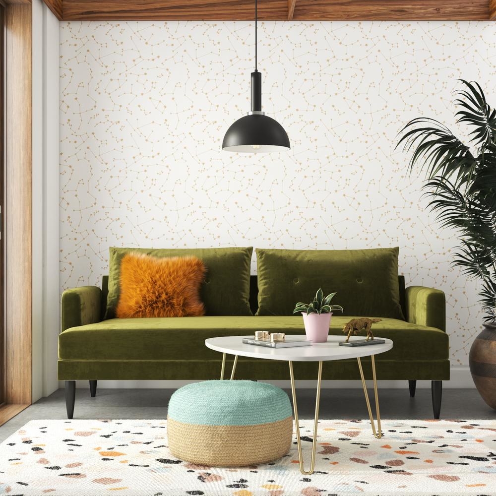 The Bailey Pillowback Sofa in olive green velvet in a living room