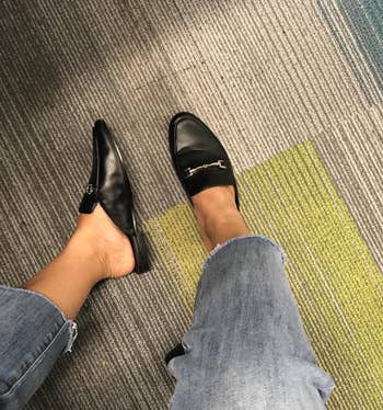 reviewer in black loafers and raw hem jeans