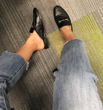 reviewer in black loafers and raw hem jeans