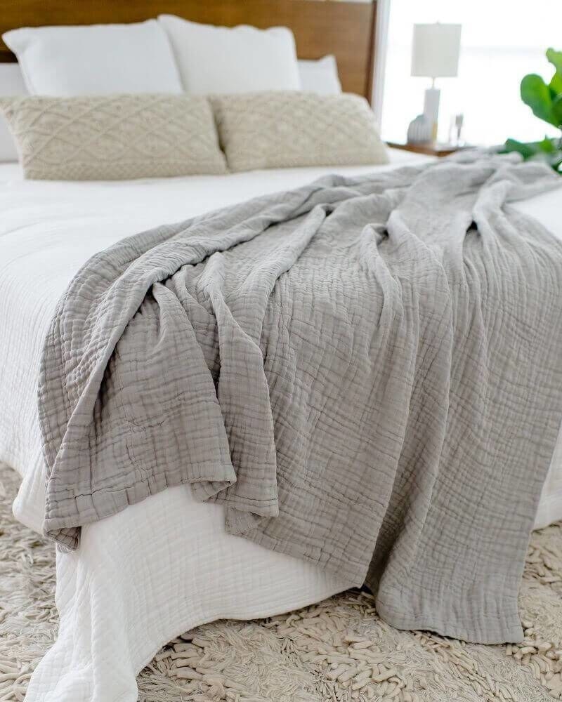 gray waffle muslin blanket draped on the end of a bed