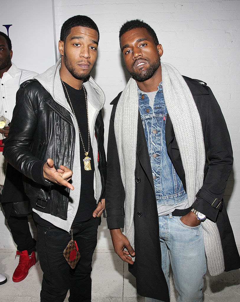 Photo of Kid Cudi with Kanye, both wearing layered clothing and jeans