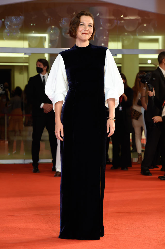 Maggie Gyllenhaal in a navy plush velvet gown with white sleeves on the red carpet for &quot;The Lost Daughter&quot;