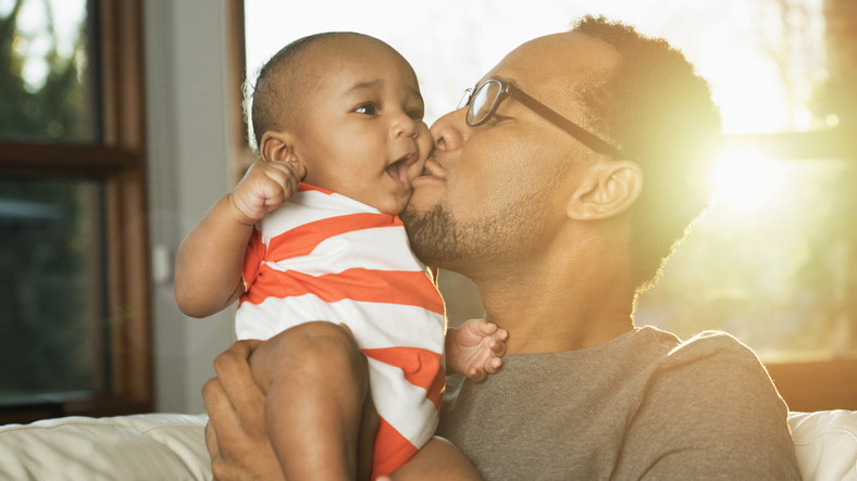 A person kissing a baby on the cheek