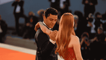 A GIF of Oscar Isaac kissing Jessica Chastain&#x27;s inner arm on the red carpet