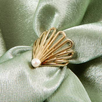 pearl at base of ring with arched gold fan around it