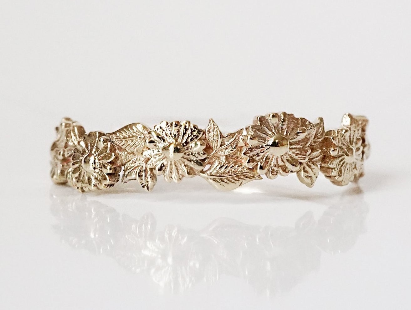 cut out band with daisies and leaves around the front of the ring