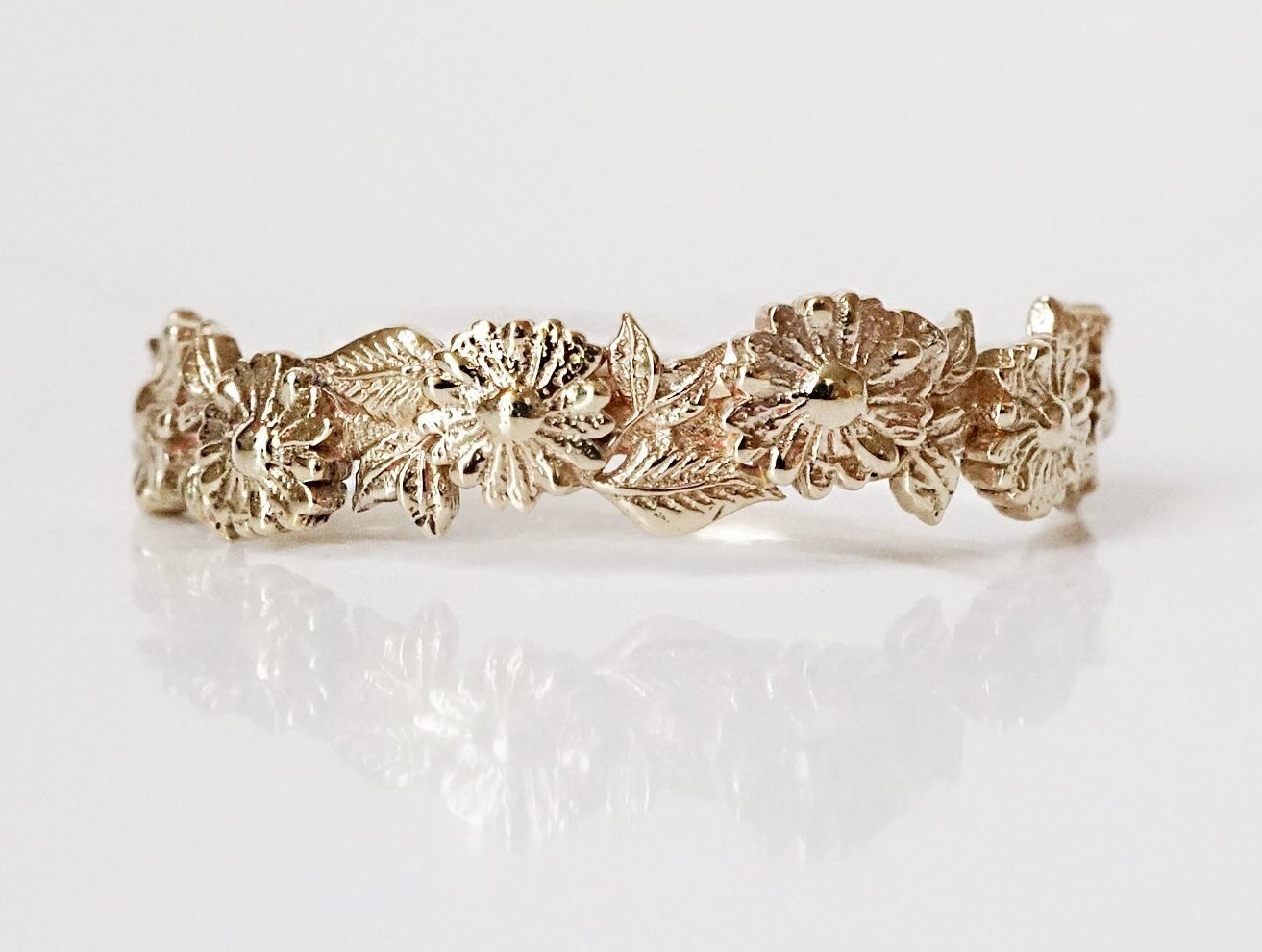 cut out band with daisies and leaves around the front of the ring