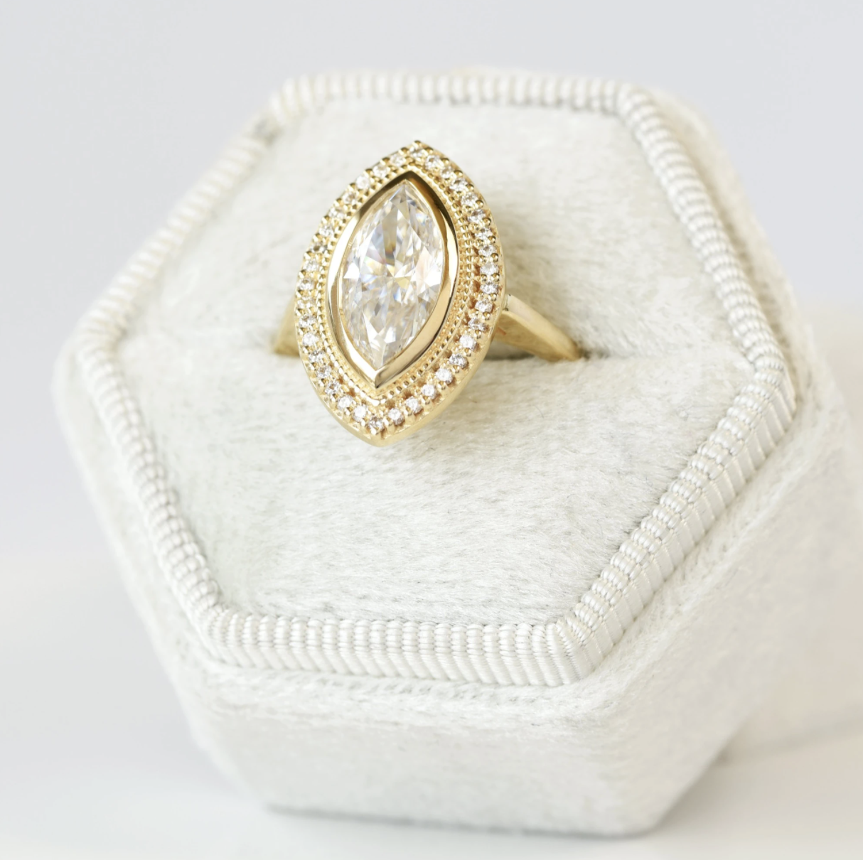halo ring in rose gold setting with smaller diamonds around center piece