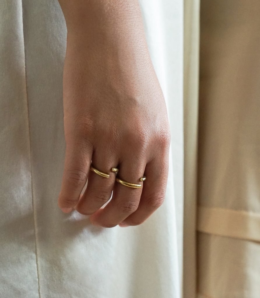 closeup of hand wearing the disconnected gold bands on two fingers