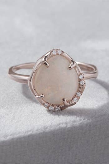 opal ring with small diamonds around the asymmetrical framed band 