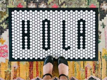 tile door mat that says hola in black and white tiles 