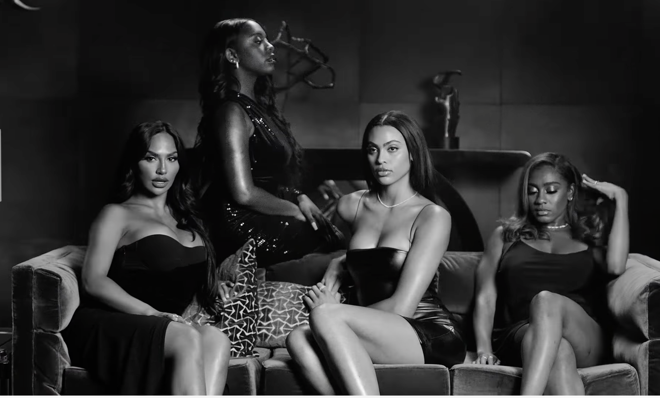 Black-and-white screenshot of four women sitting on a couch