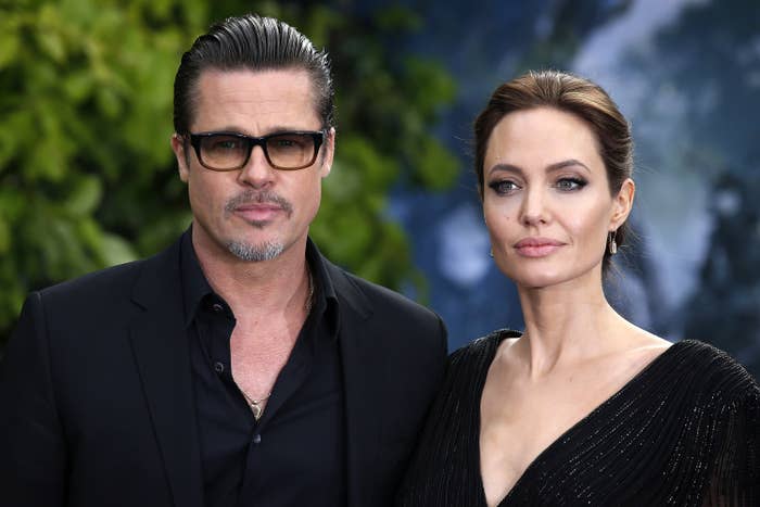 Brad in glasses with Angelina, both looking serious