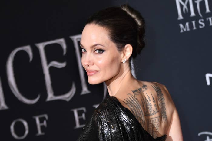 Angelina on the red carpet showing a back tattoo