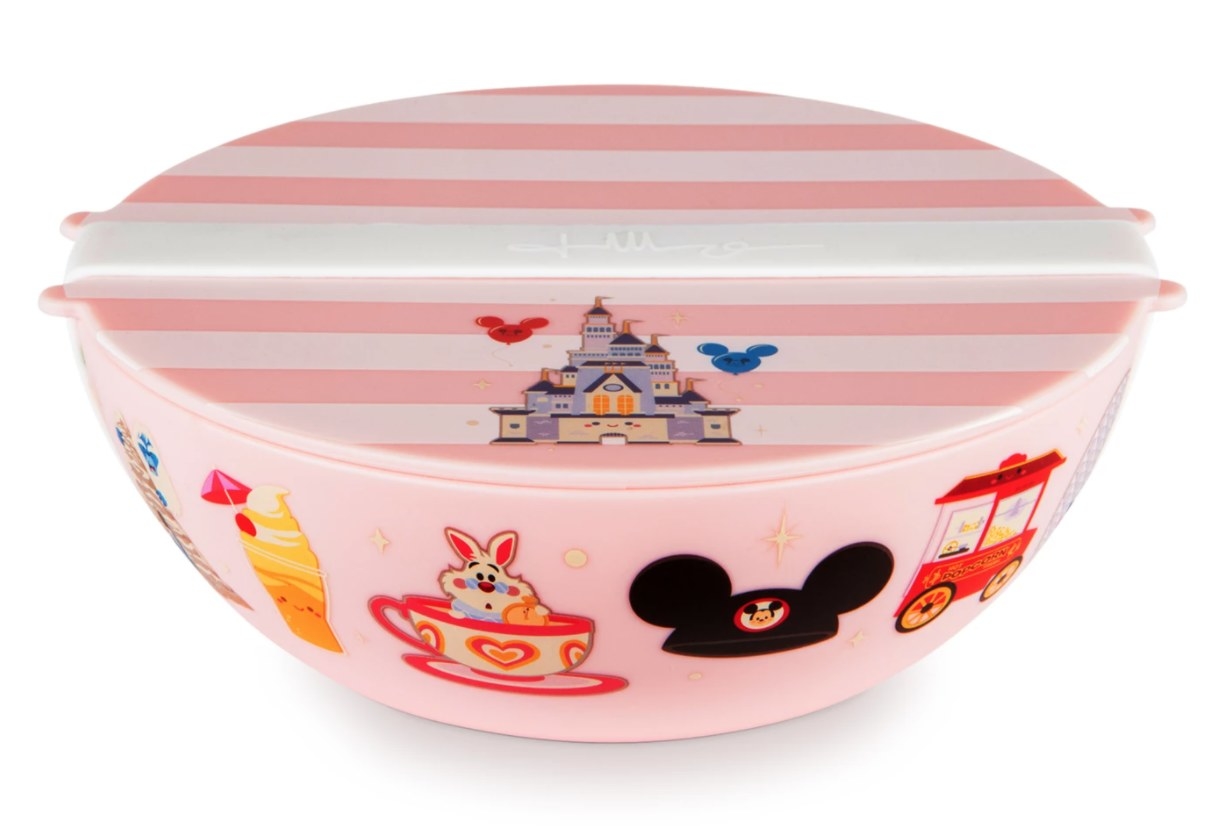 A pink travel bowl with lid and silicone strap with icons of Disney parks