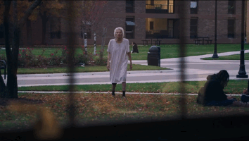 Woman in white creepily walks toward window