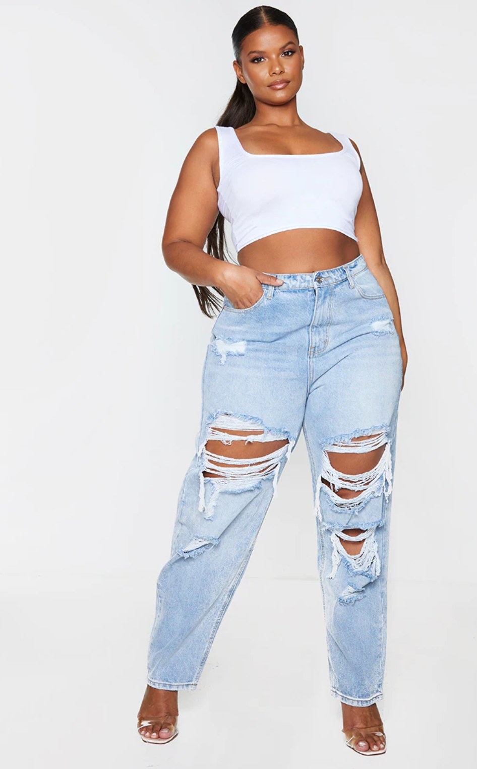 model wearing the ripped mom jeans and a cropped white shirt