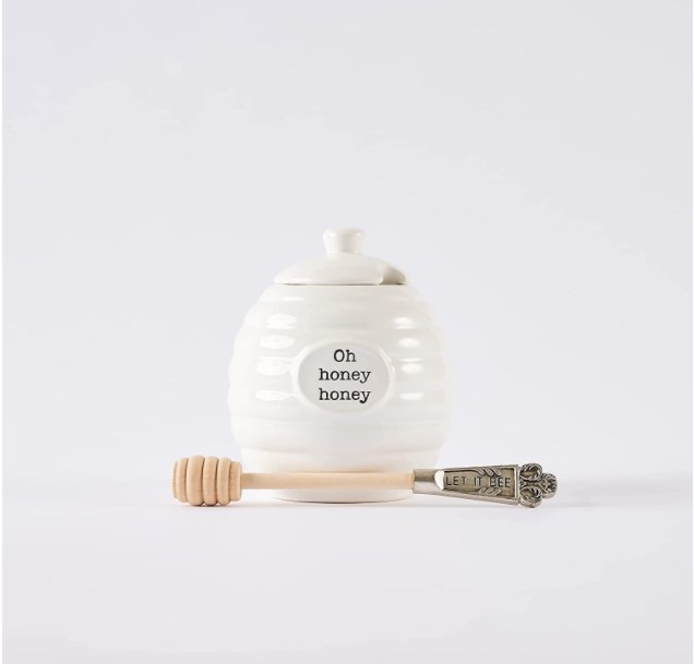 Foto de jarro pequeño para guardar miel con cuchara de madera para servirla