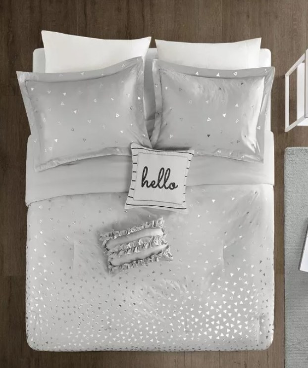 Gray metallic printed bed spread with a a pillow that says "Hello!"