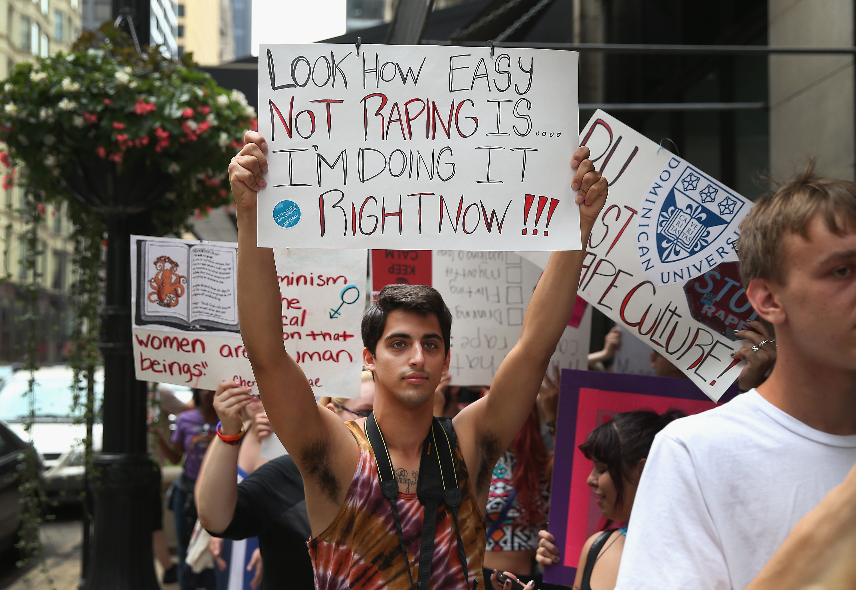 Demonstrator participating in Slutwalk with a sign reading, &quot;Look how easy not raping is, I&#x27;m doing it right now,&quot; marches through downtown in Chicago, Illinois