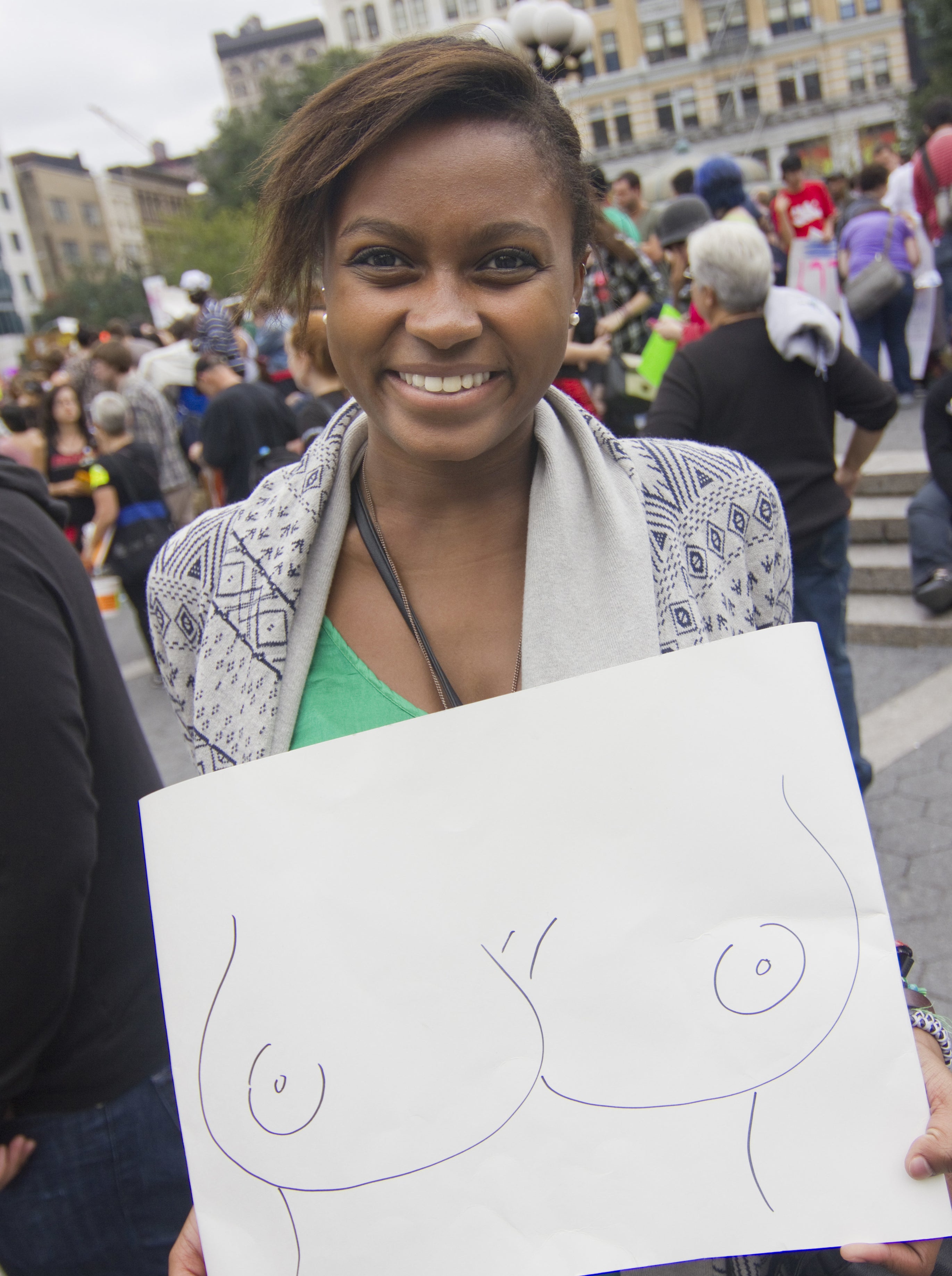 A woman with a sign depicting breasts participates in SlutWalk NYC, rallying in Union Square and marching through the East Village