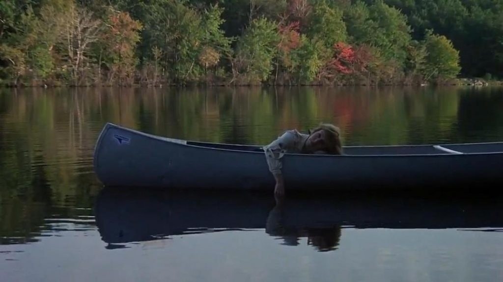 A woman is passed out in a canoe on the lake