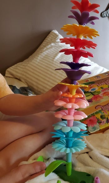 Reviewer's photo of plastic flower toys stacked into a tower