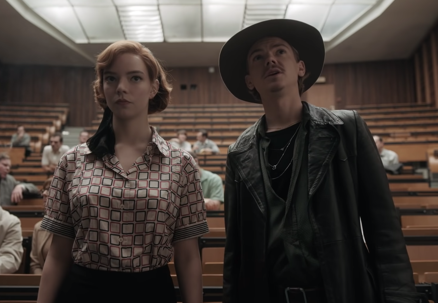 Beth and Benny stand side by side in a half empty conference hall