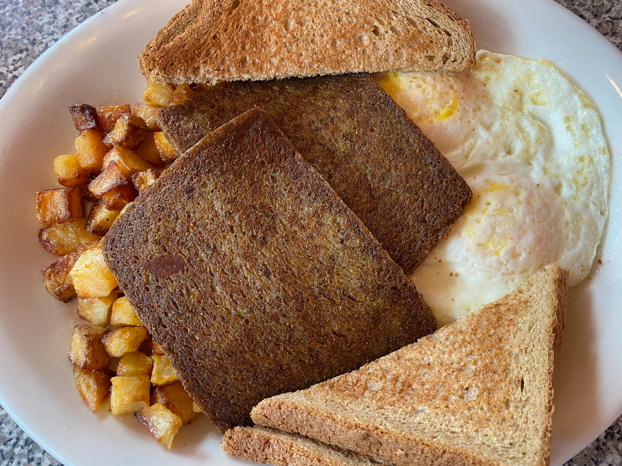 Scrapple, eggs, potatoes, and toast.