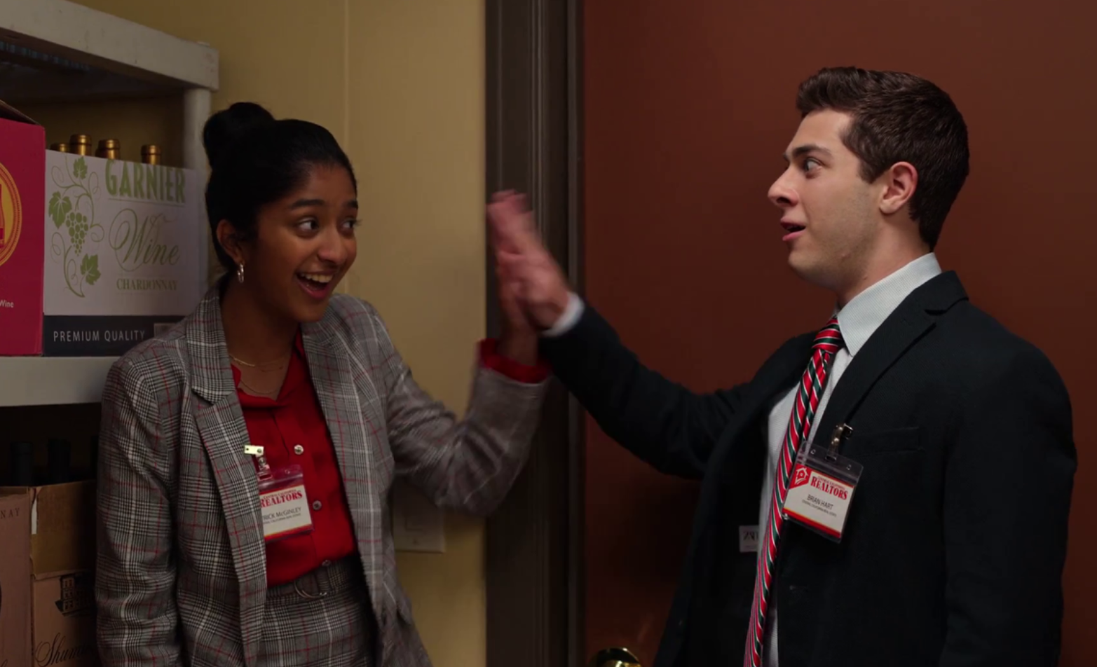 Devi and Ben share a high five while standing in a closet