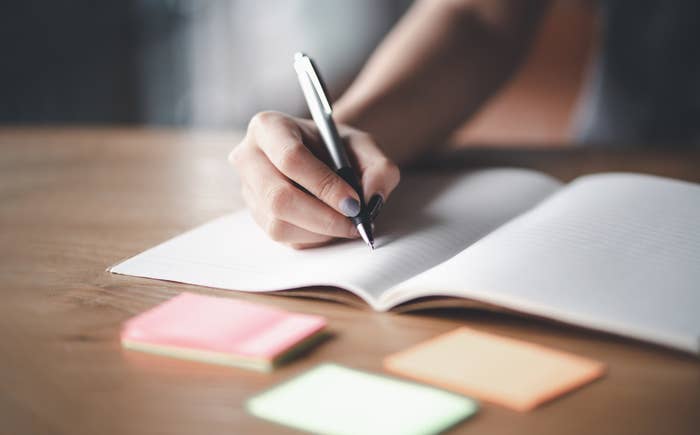 A stock image of someone writing in a journal