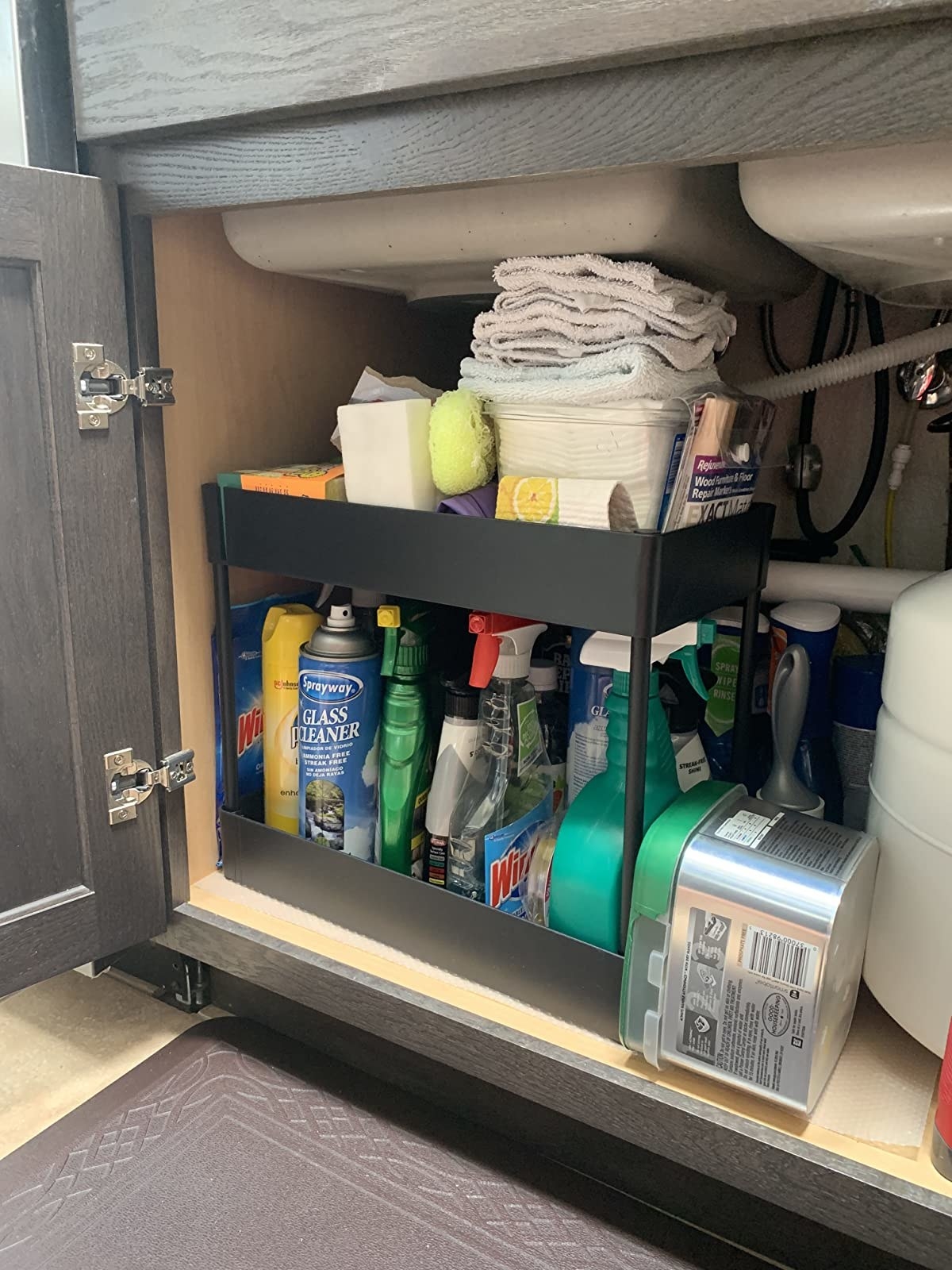 reviewer image of the black two-tier organizer under a kitchen sink