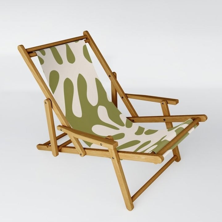 a matisse-inspired sling chair with a green leaf print