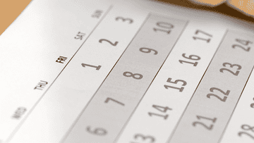 a hand circling a date on a calendar
