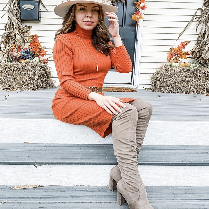 reviewer wearing orange dress with over-the-knee boots