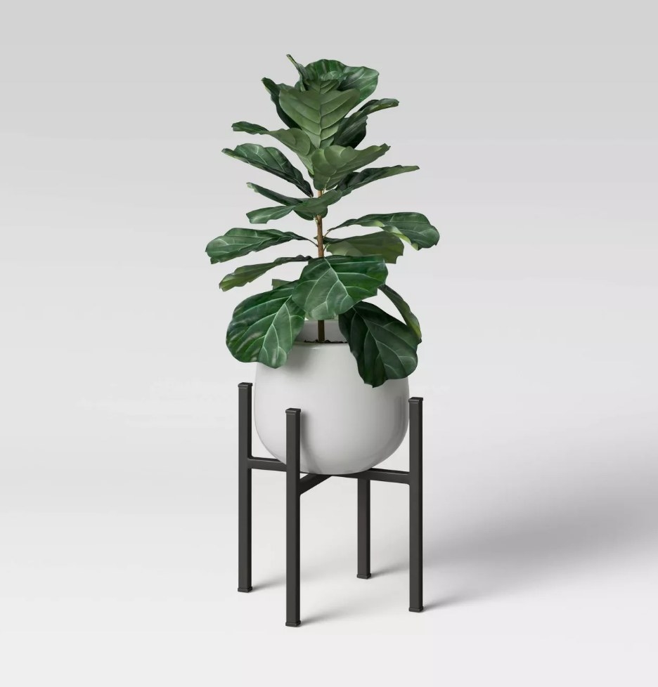 A white, ceramic planter on a black, metal stand