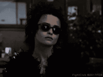A GIF of a woman taking her sunglasses off
