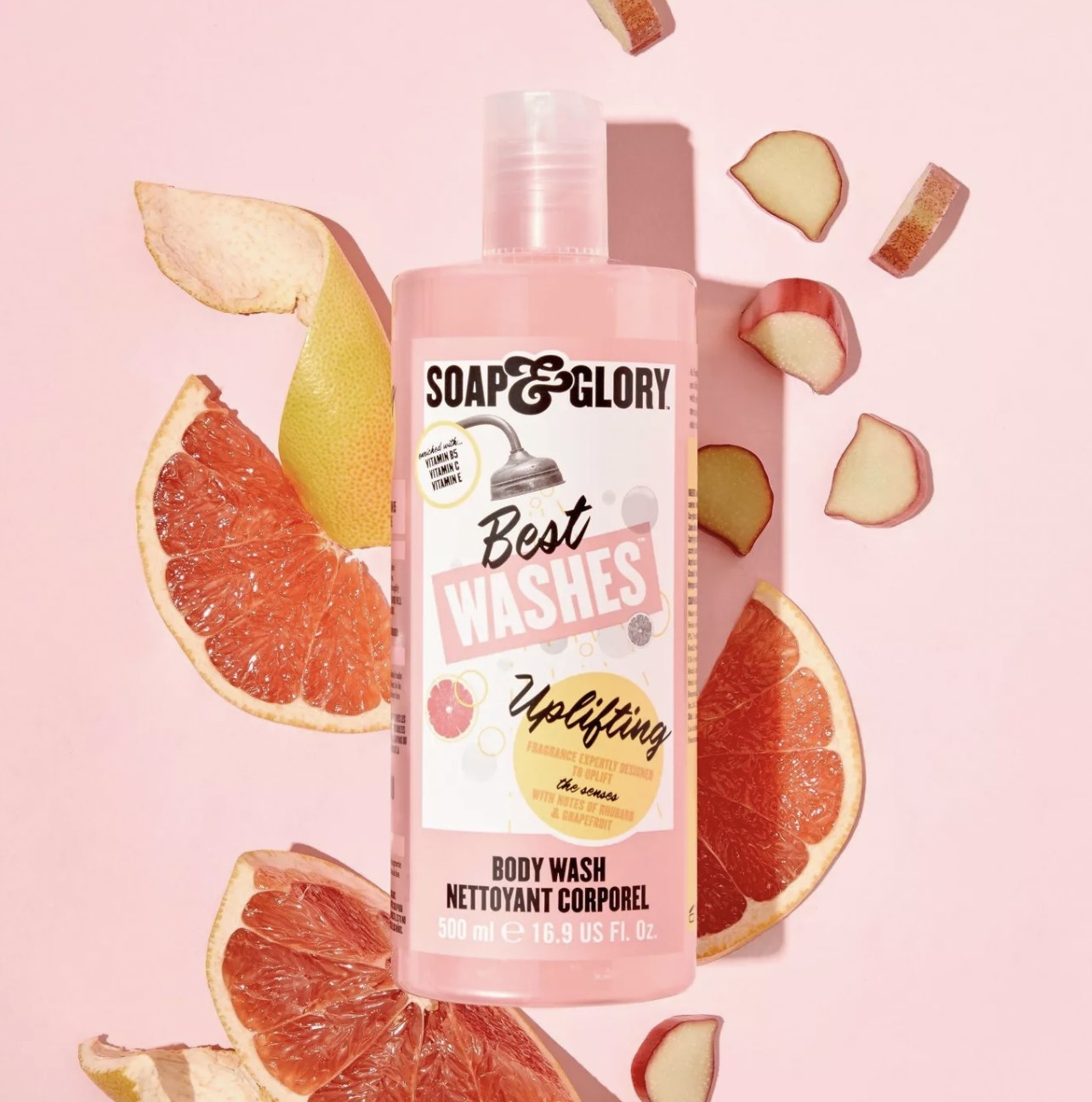 a body wash in a flat lay with grapefruit and fruit bits