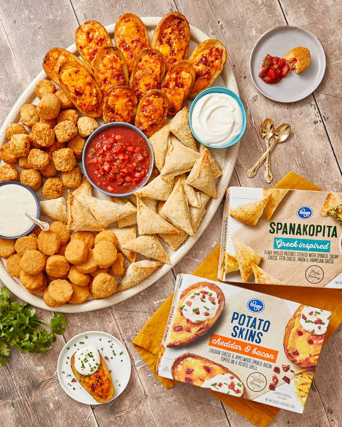 Platter with appetizers and small bowls of ranch and sour cream and salsa