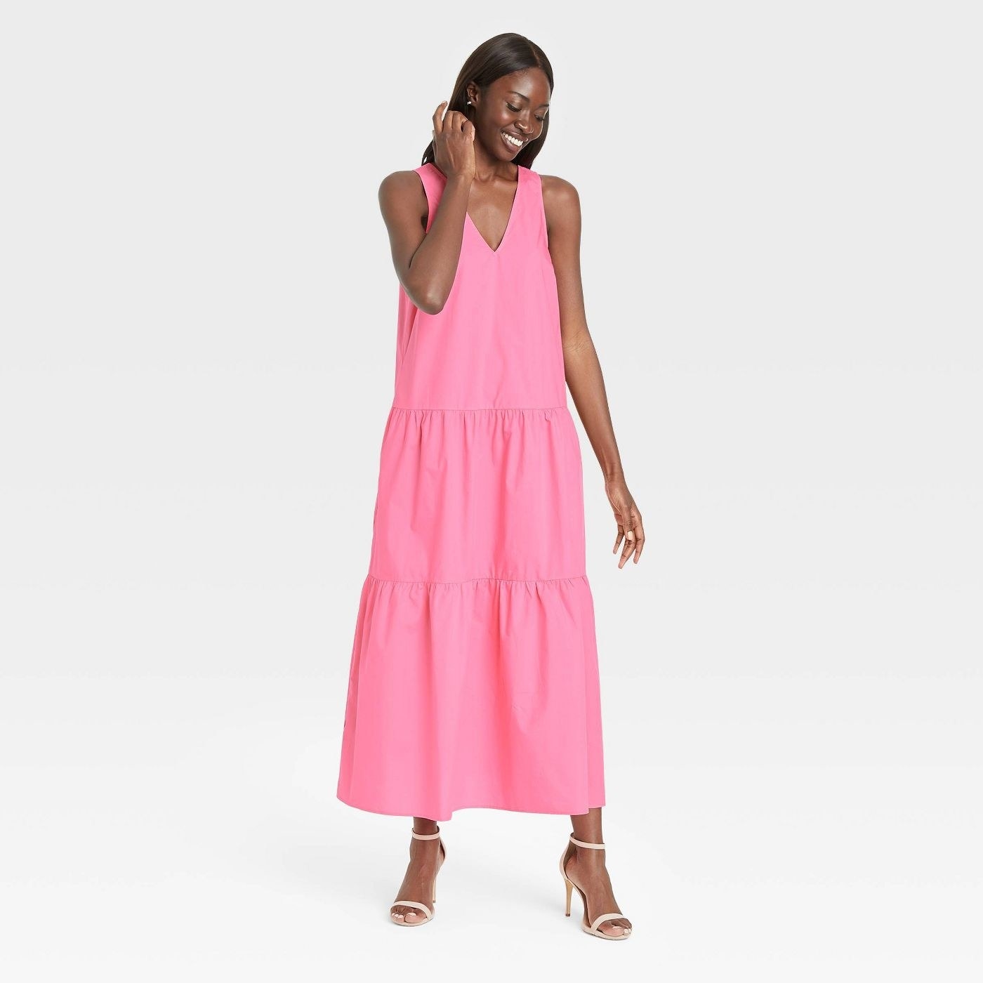 A model wearing a pink sleeveless tiered maxi dress