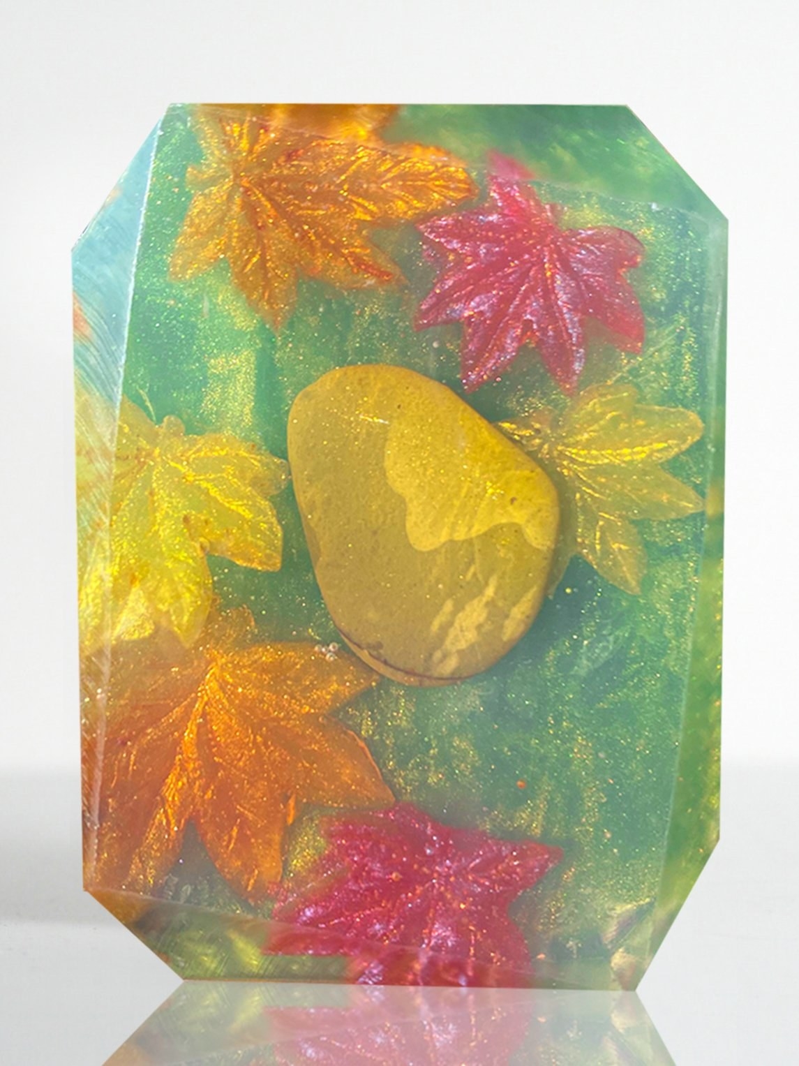 a bar of soap with leaves in it and a crystal stone