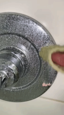 GIF of reviewer scrubbing away rust on faucet with The Pink Stuff
