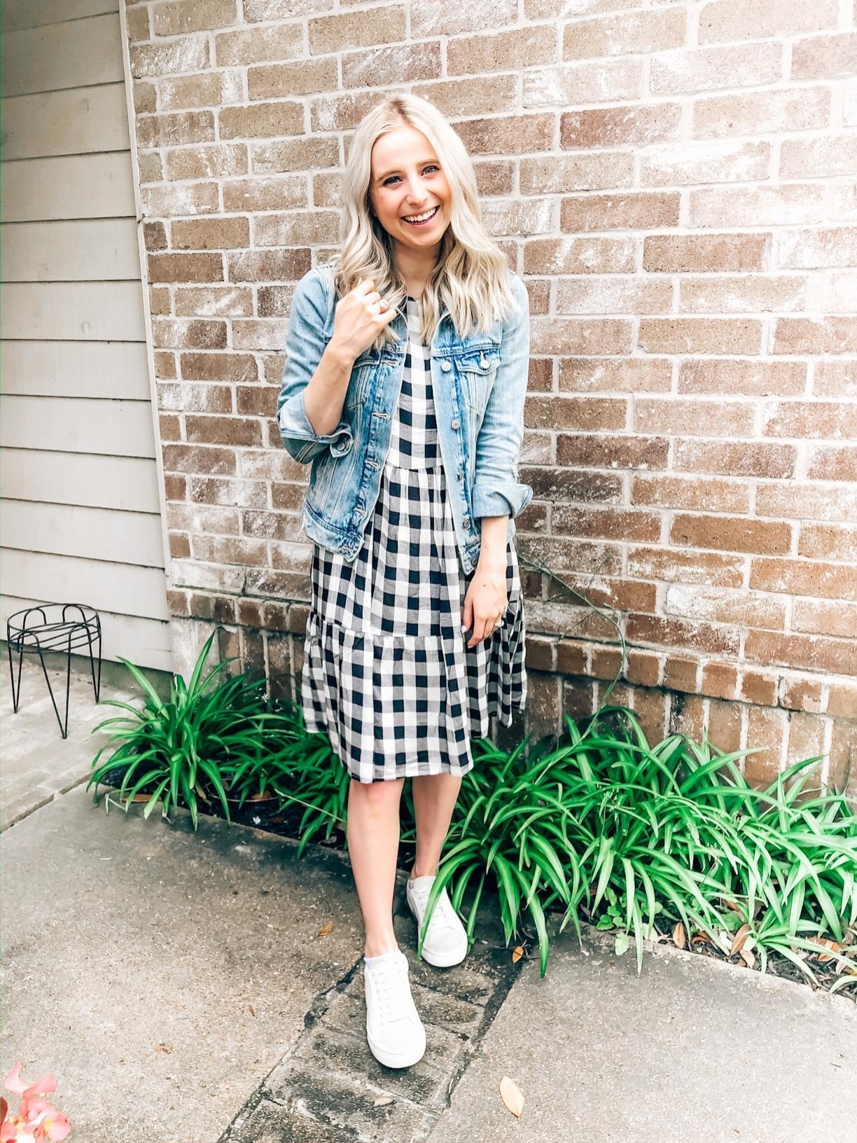 reviewer wears the dress with a cropped light wash jean jacket and white sneakers