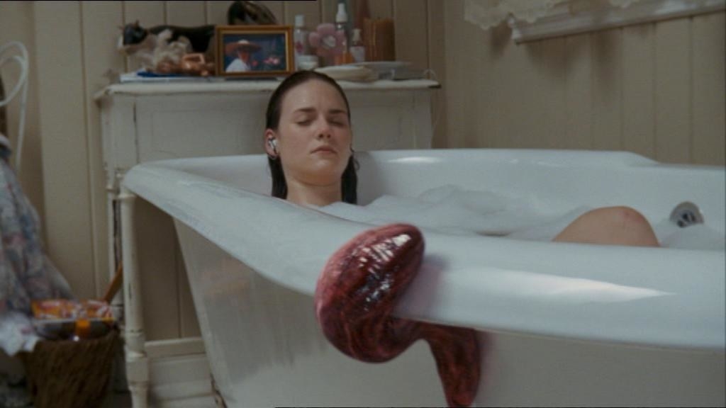 Red slug slithers into a bath and near an unaware bathing woman