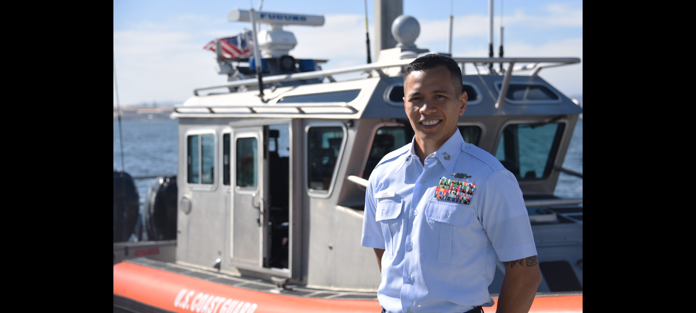 Chief Petty Officer Deren Perez poses on the bow of a U.S. Coast Guard ship