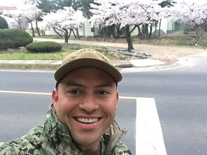 MST2 Robert Alvarenga taking a selfie in military clothing in front of cherry blossom trees in South Korea