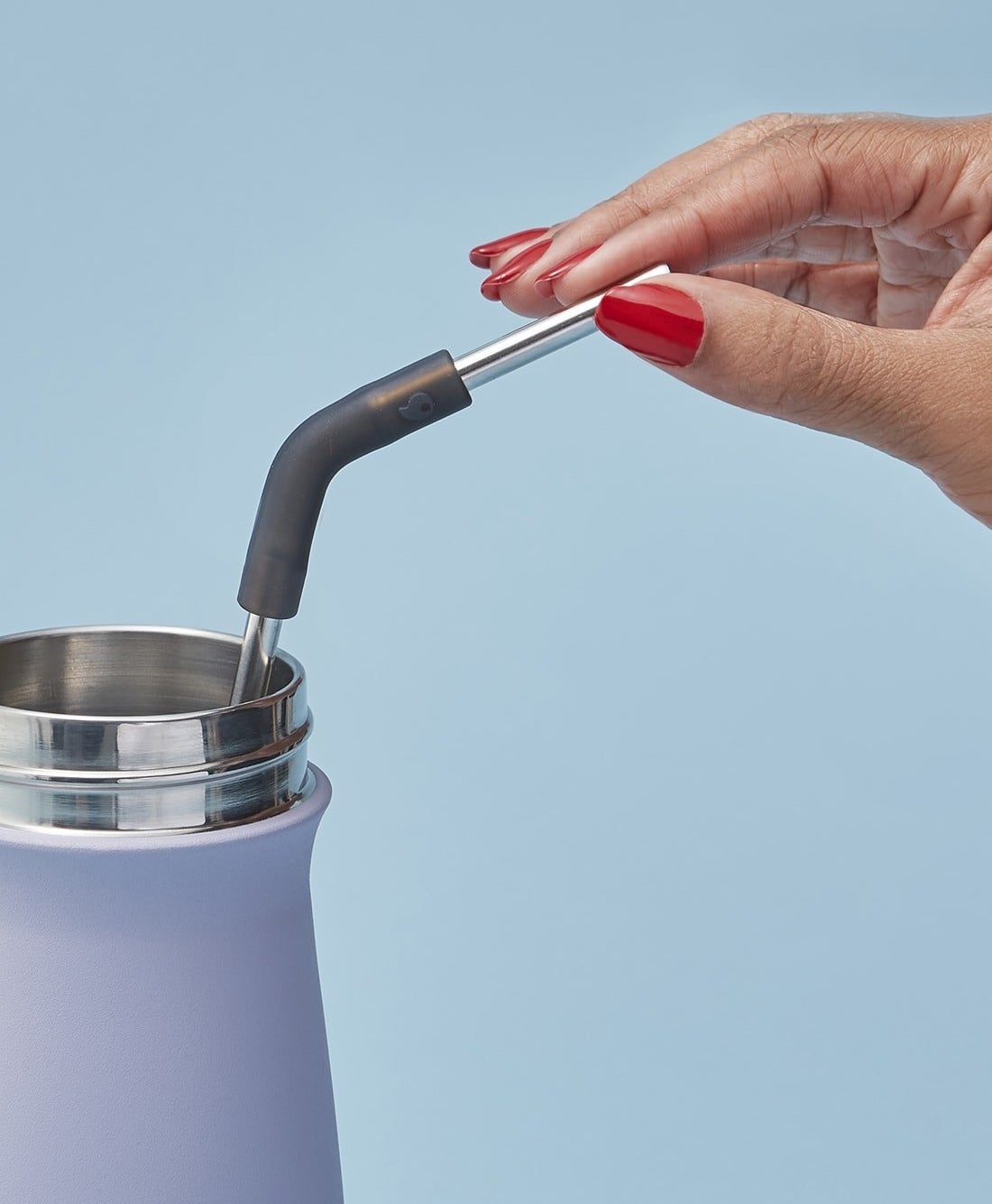 manicured hand holds black reusable straw in S&#x27;well tumbler